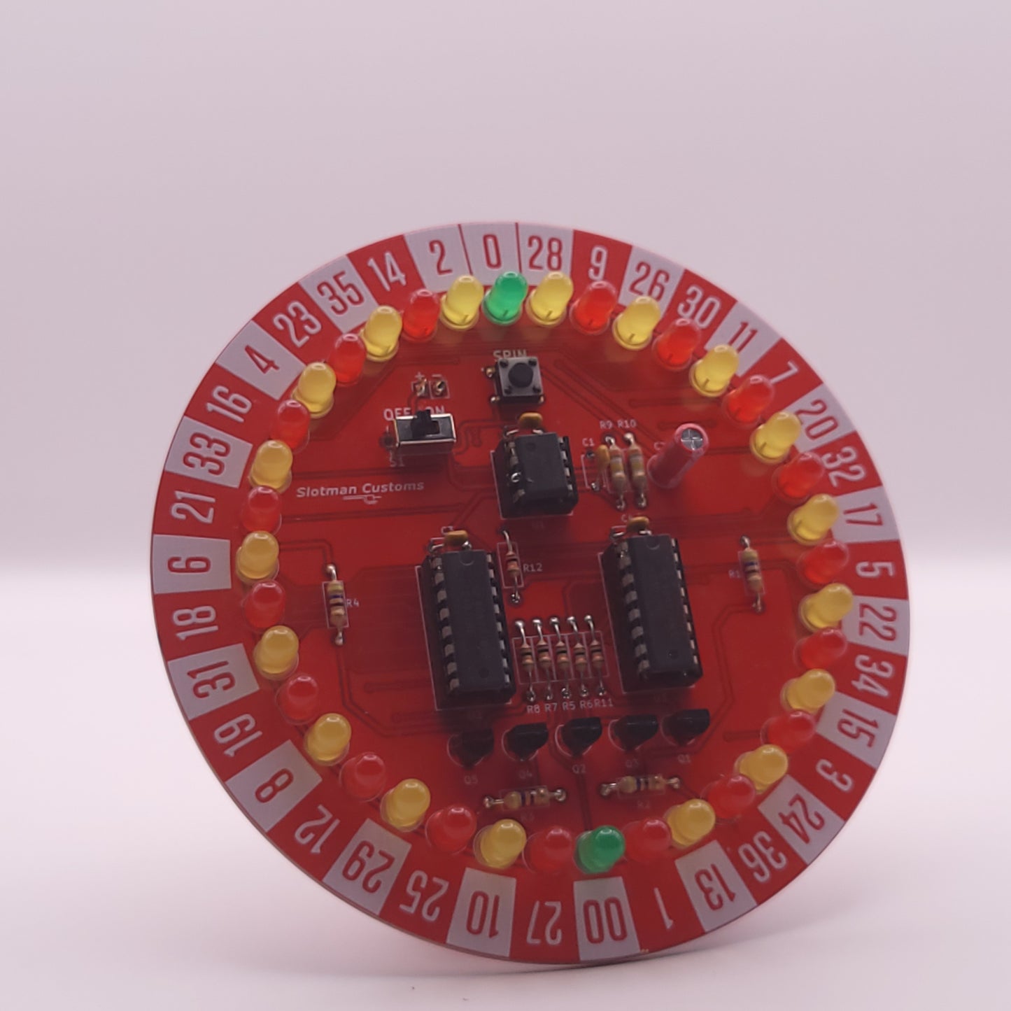 Circular electronic component with red background and various components on a white background