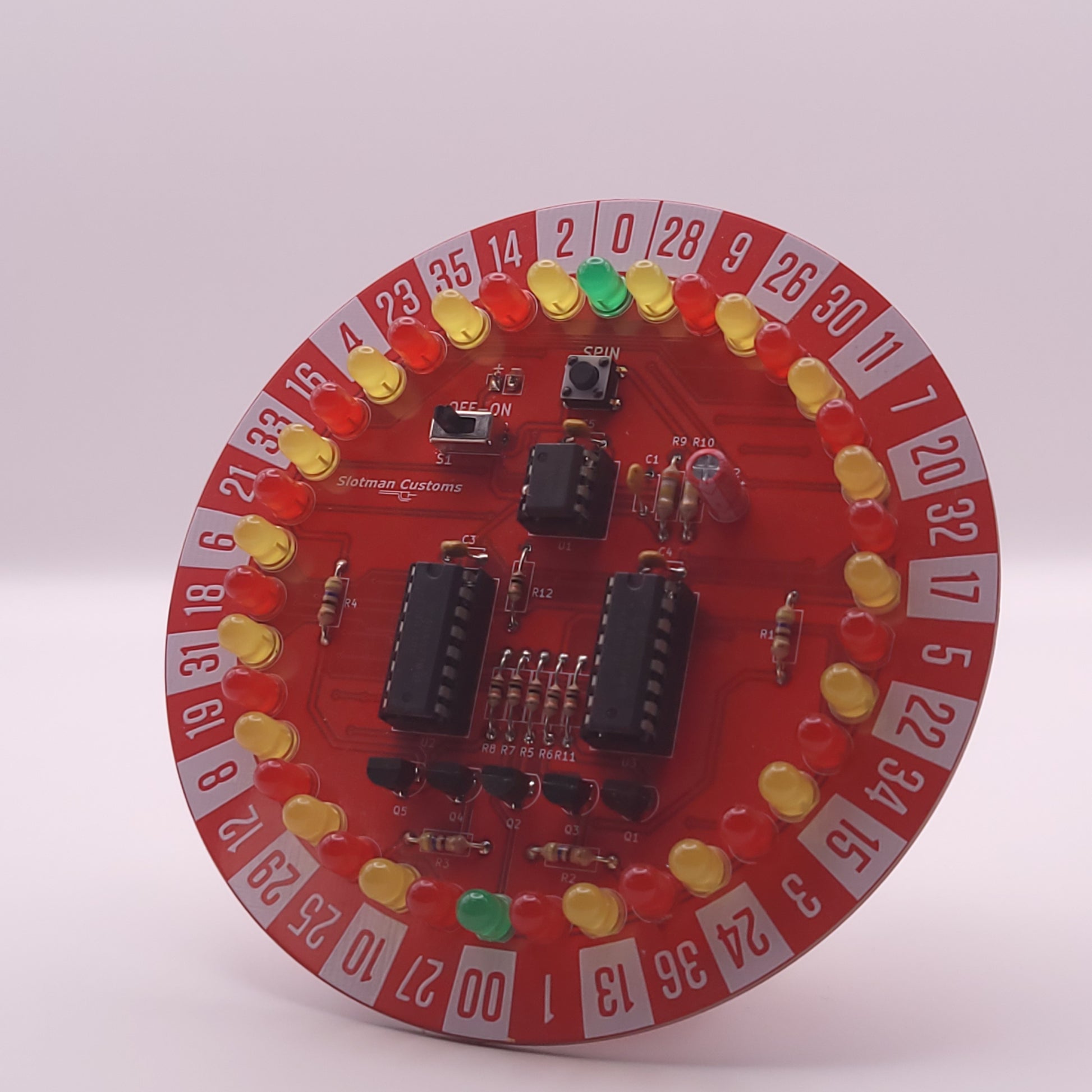 Circular electronic component with red background and various components on a white background